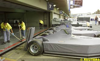 workers clean the garages ahead of the GP