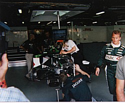 Johnny Herbert walks through the Jaguar pits