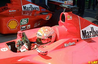 Michael Schumacher, Ferrari, wearing his Bell helmet, in parc ferme after securing pole position