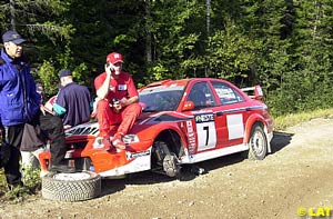 Makinen sits on the bonnet of his broken Lancer