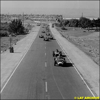Stirling Moss (Vanwall VW5) leads Phil Hill (Ferrari Dino 246) at the start of the race