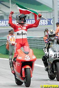 Winner Max Biaggi returns to the pits after winning the Malaysian race, Italian flag in hand