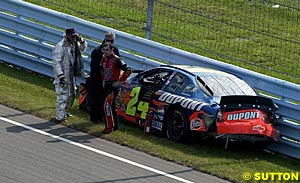 A frustrated Jeff Gordon stands beside his crumpled car