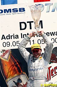 Winner Christijan Albers holds his trophy aloft on the podium