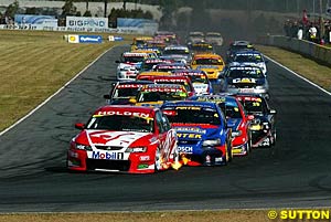 The field heads into turn three on lap one, Mark Skaife leading Marcos Ambrose