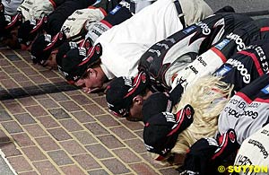 Kevin Harvick and his crew kiss the yard of bricks after winning the Brickyard 400