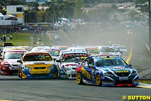 The Marcos Ambrose/Russell Ingall car leads the field through turn one at the start