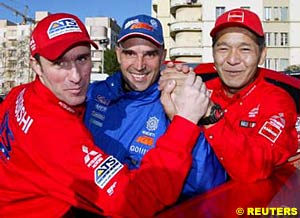 Current leader (car) Stephane Peterhansel, third place (bike) Fabrizio Meoni and second place (car) Hiroshi Masuoka pose before the start of the Dakar