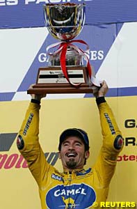 Max Biaggi holds the winner's trophy aloft at Motegi