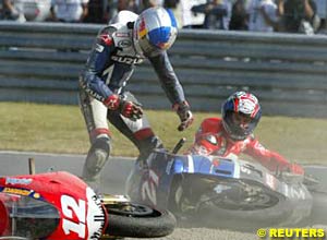 John Hopkins stands up while Troy Bayliss looks on after the first turn collision