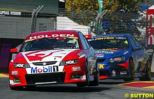 Race two winner Mark Skaife in his VY Commodore leads race one winner Marcos Ambrose in his BA Falcon