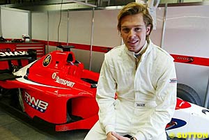 Sam Hancock sits on a front tyre of an Arden International car during testing earlier this month