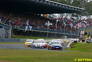 Marcos Ambrose leads the field through turn one at the start of the race