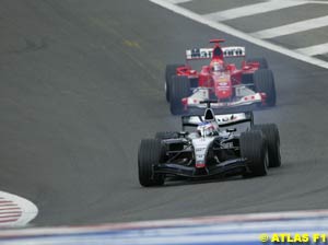 Kimi Raikkonen in the McLaren-Mercedes leads Michael Schumacher's Ferrari