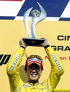 Makoto Tamada with the winner's trophy on the podium