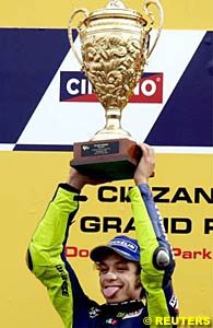 Valentino Rossi holds the winner's trophy aloft