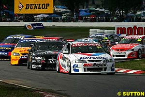 Garth Tander leads Craig Baird at the start while Ambrose starts heading towards the grass in the background