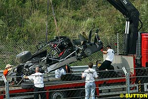 The remains of Peter Dumbreck's Opel Vectra are craned away