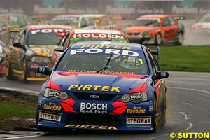 Race one winner Marcos Ambrose leads the field on lap one of race one