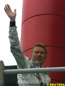 Hakkinen waves to the crowd after setting pole