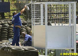 workers at Interlagos prepare special cages to protect track marshals